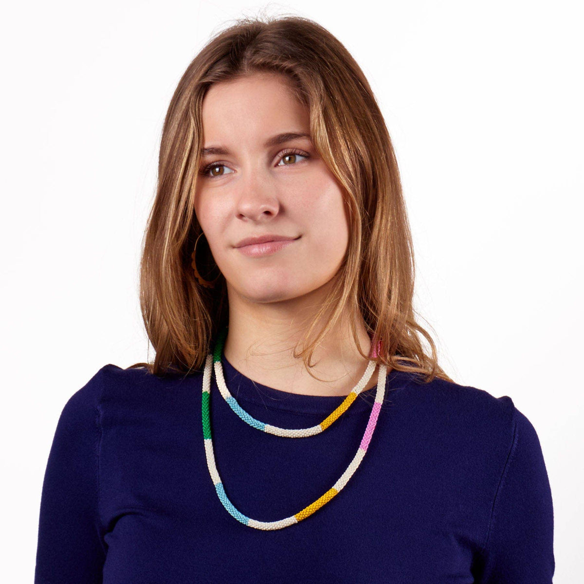 Woman wearing a colorful beaded necklace on a white background