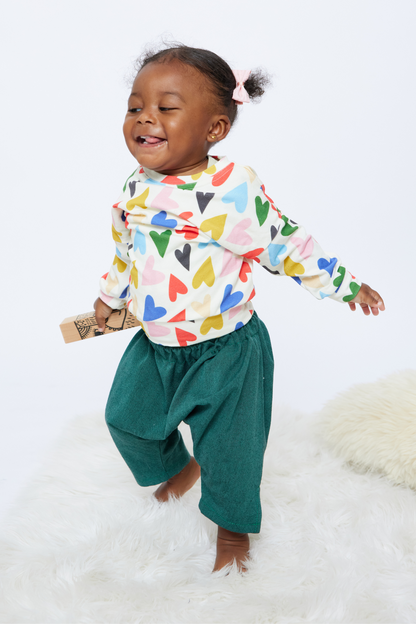 joyful baby walking and wearing ethically made green baby pants