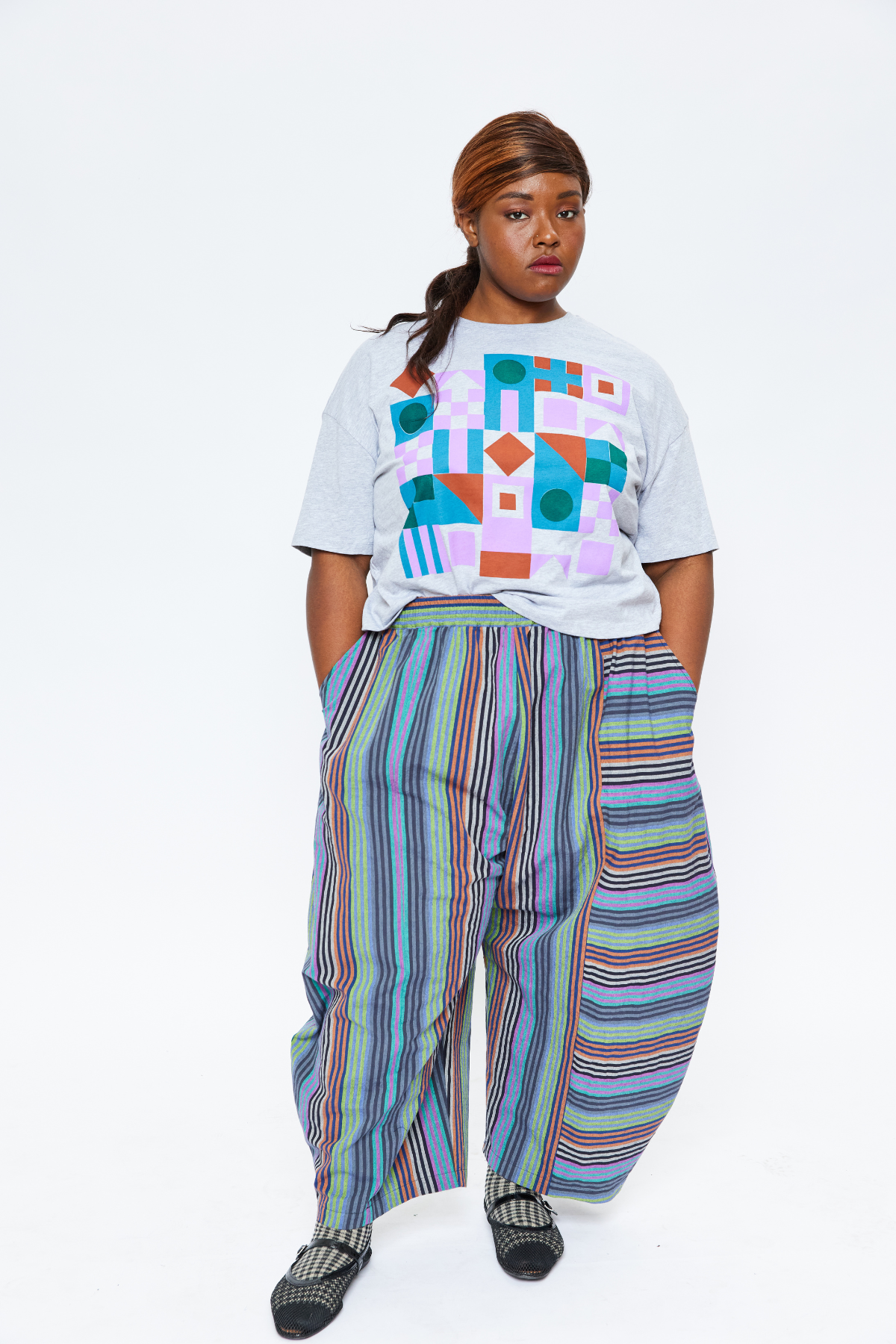 Plus size standing with her hands in her pockets. She looks very cool while wearing sustainable cotton elastic waist pants.