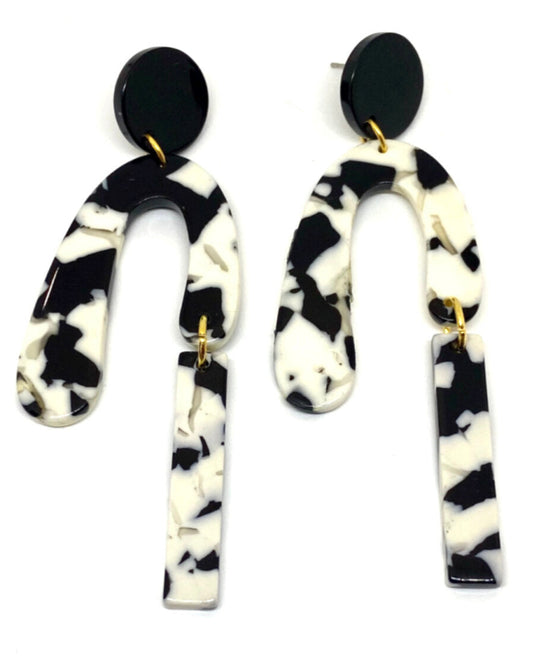 A pair of black and white marbled earrings with a gold plated metal accent, displayed against a white background.